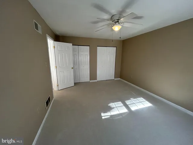 an empty room with closet and wooden door