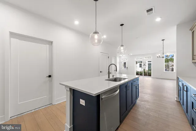 a kitchen with stainless steel appliances granite countertop a sink a oven a dining table and chairs