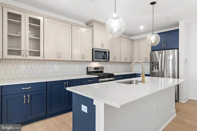 a kitchen with a sink a stove a refrigerator and cabinets