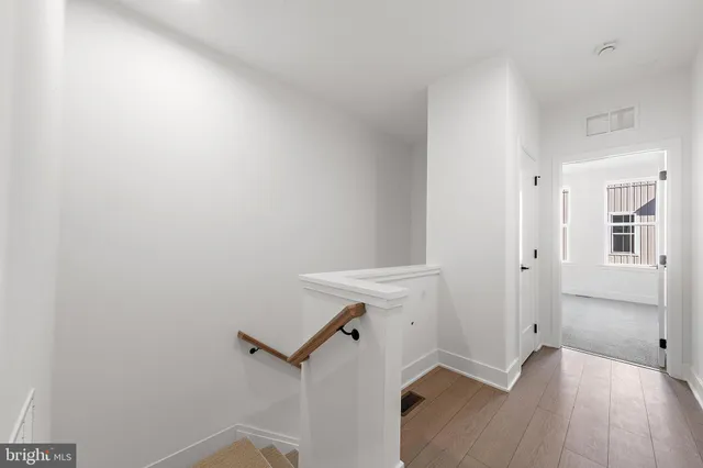 a view of empty room with wooden floor