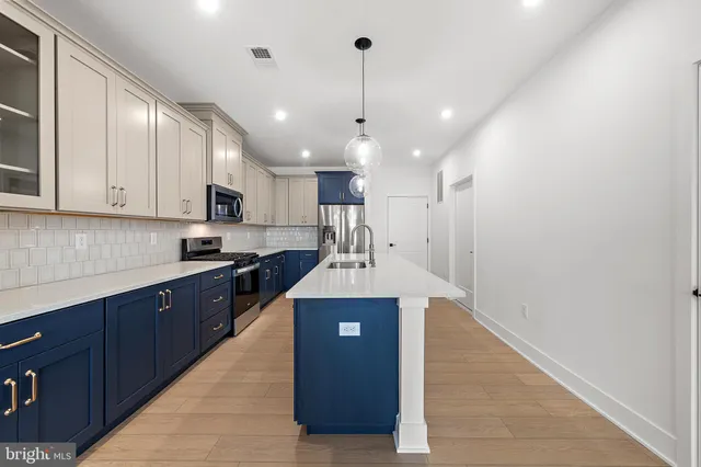 a kitchen with kitchen island a counter top space a sink and cabinets