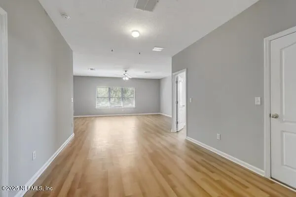 a view of a room with a ceiling fan and a window