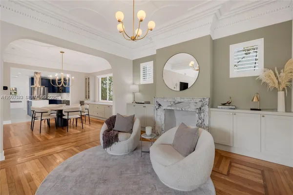 a view of a dining room with furniture a chandelier and wooden floor
