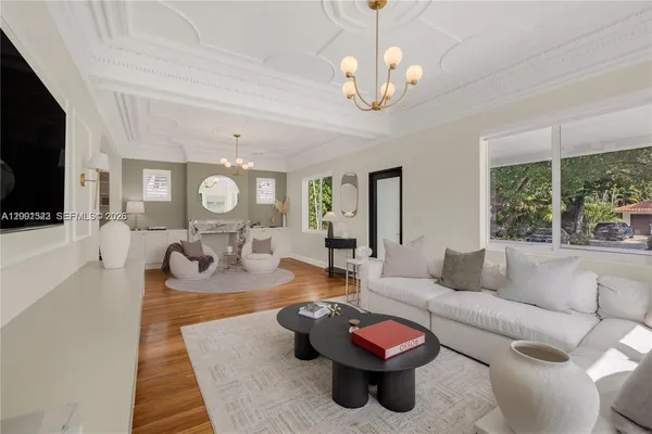 a living room with furniture chandelier and a fireplace