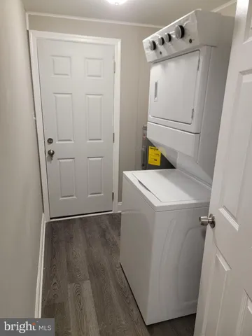 a utility room with wooden floor washer and dryer