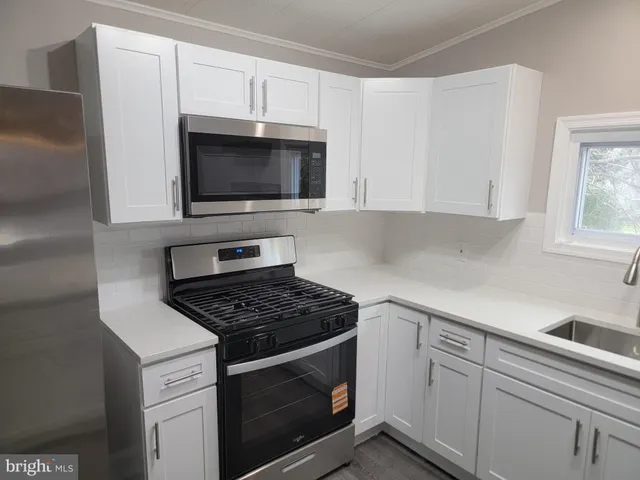 a kitchen with white cabinets and appliances