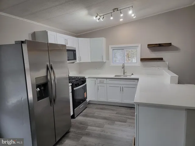a kitchen with a sink stainless steel appliances and cabinets