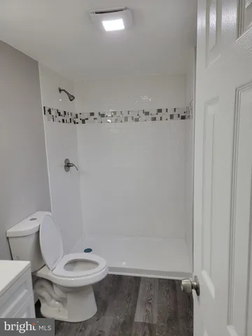 a white toilet sitting next to a shower
