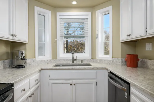 a kitchen with granite countertop a sink cabinets and window