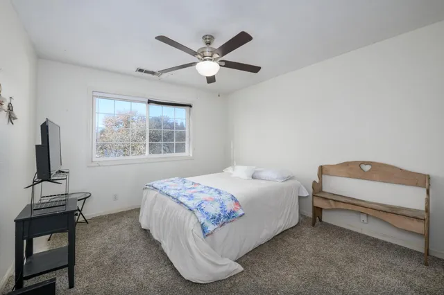 a bedroom with a bed next to a window with a sink