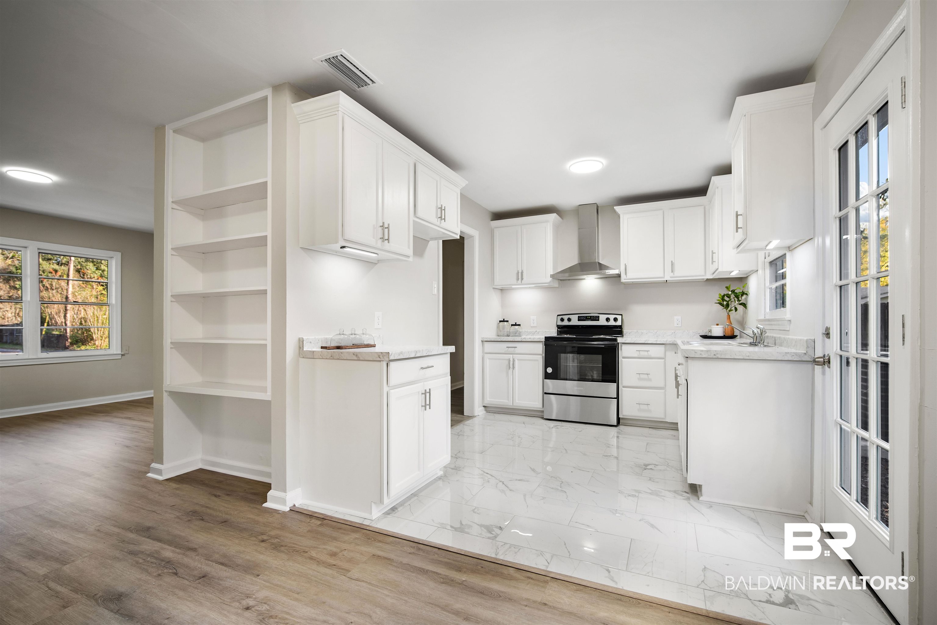 662 Merritt Drive Mobile, AL 36609 - Photo 9 of 21 Kitchen featuring stainless steel electric stove, white cabinets, wall chimney exhaust hood, light wood-type flooring, and light stone counters