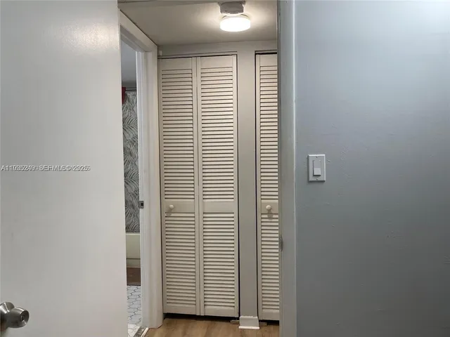 a view of bathroom with a sink mirror and cabinets