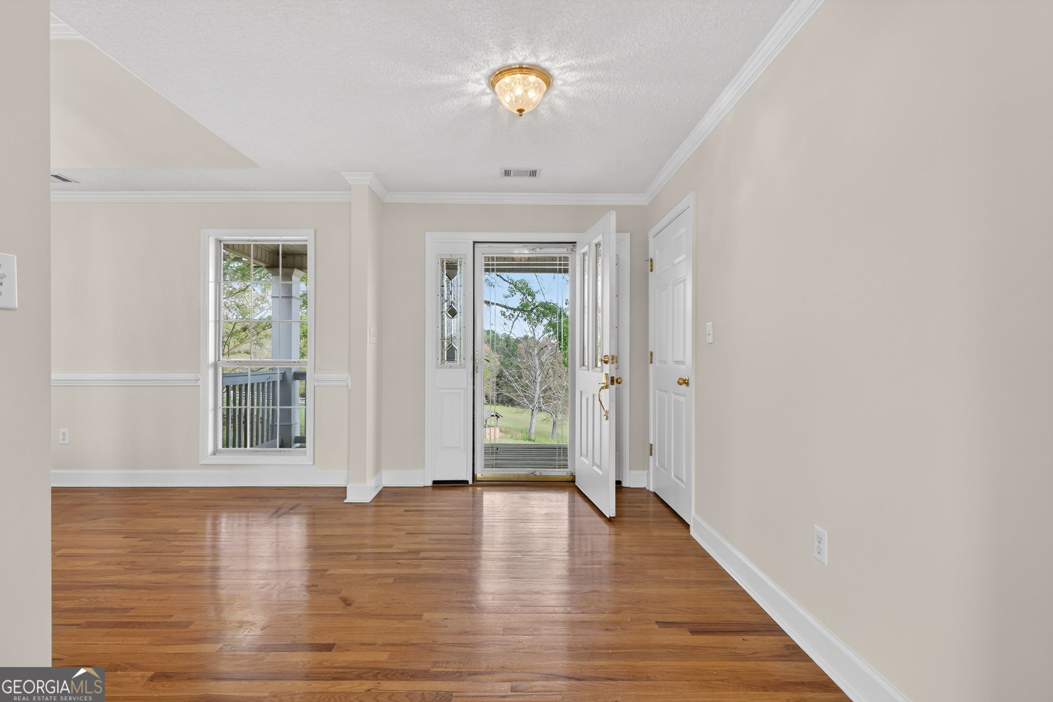 955 Mocassin Gap Road Locust Grove, GA 30248 - Photo 6 of 59 a view of an empty room with wooden floor and a window