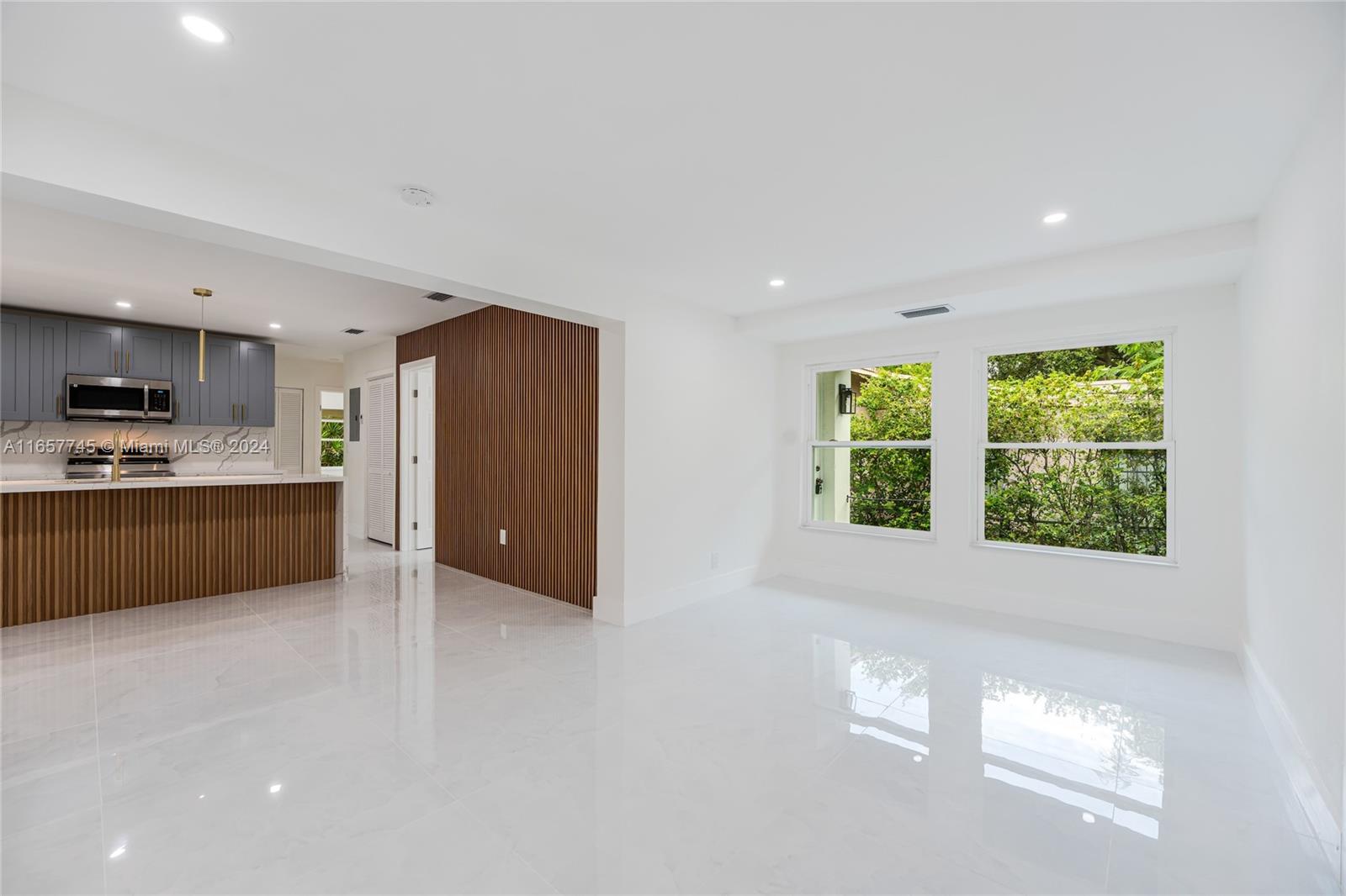 4802 Northwest 11th Avenue Miami, FL 33127 - Photo 4 of 26 a view of kitchen with stainless steel appliances granite countertop a refrigerator a sink a stove and a window
