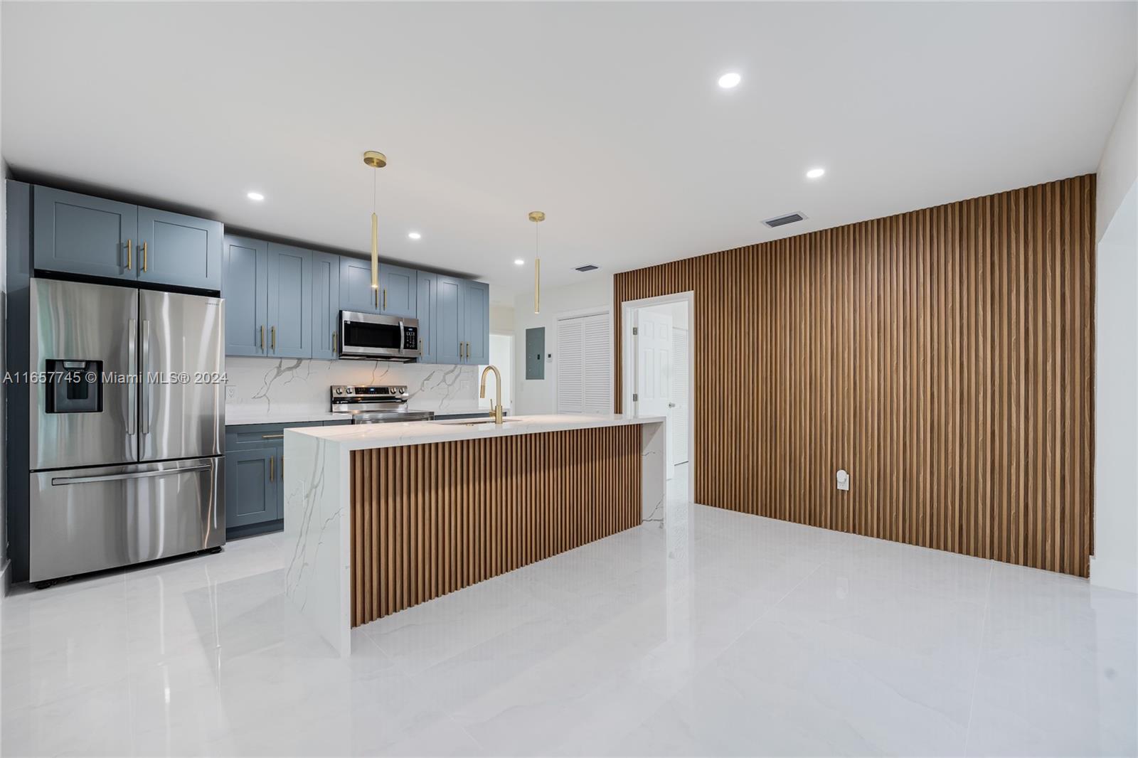 4802 Northwest 11th Avenue Miami, FL 33127 - Photo 5 of 26 a kitchen with stainless steel appliances granite countertop a refrigerator sink and cabinets