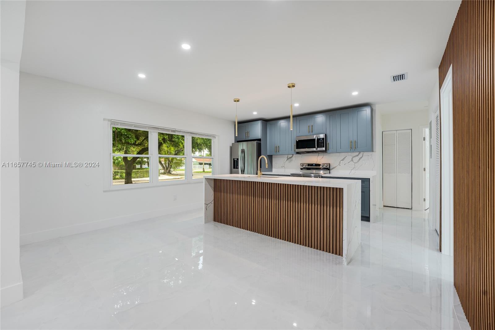 4802 Northwest 11th Avenue Miami, FL 33127 - Photo 6 of 26 a kitchen with stainless steel appliances a refrigerator sink and microwave