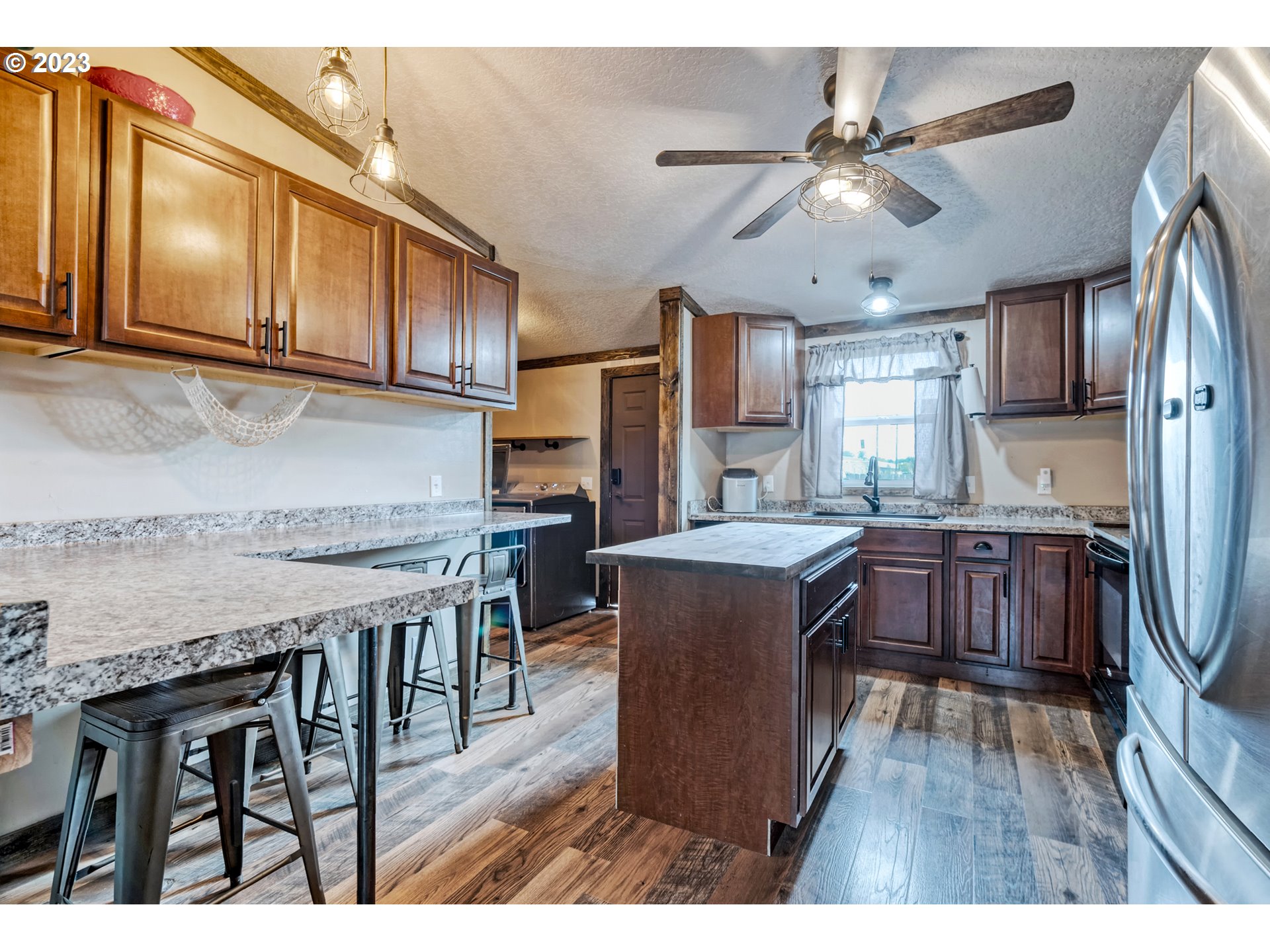 1195 38th Street Springfield, OR 97478 - Photo 8 of 26 a kitchen with stainless steel appliances granite countertop a kitchen island hardwood floor sink stove dining table and chairs