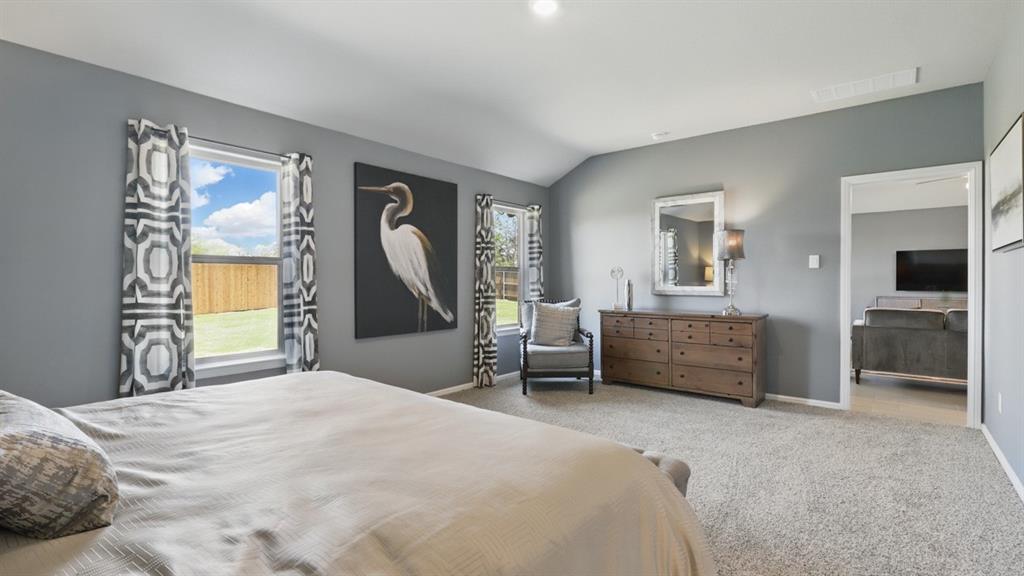 3004 McCormick Street Denton, TX 76205 - Photo 20 of 35 a bedroom with a large bed and a chandelier