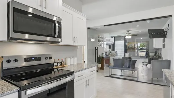 a kitchen with kitchen island granite countertop a sink cabinets and stainless steel appliances