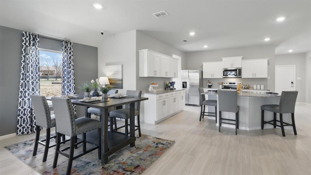 3004 McCormick Street Denton, TX 76205 - Photo 8 of 35 a kitchen with a dining table chairs and white appliances