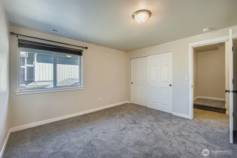 an empty room with a window and closet
