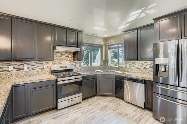 a kitchen with stainless steel appliances granite countertop a stove and a refrigerator