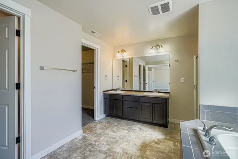 a spacious bathroom with a mirror and a sink