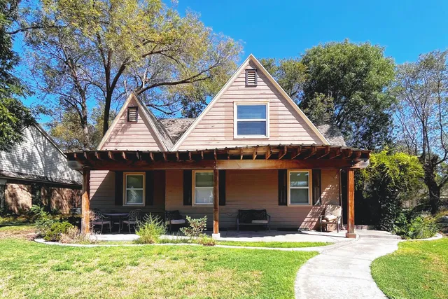 a view of house with yard and outdoor seating