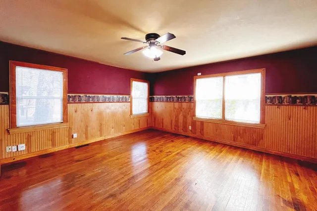 a view of an empty room with window and wooden floor