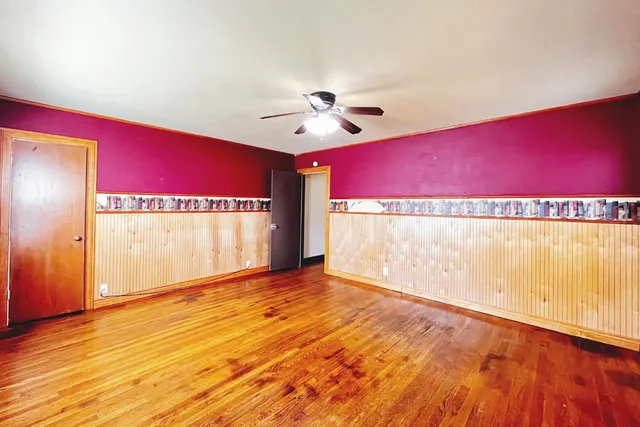 a view of an empty room with window and a ceiling fan
