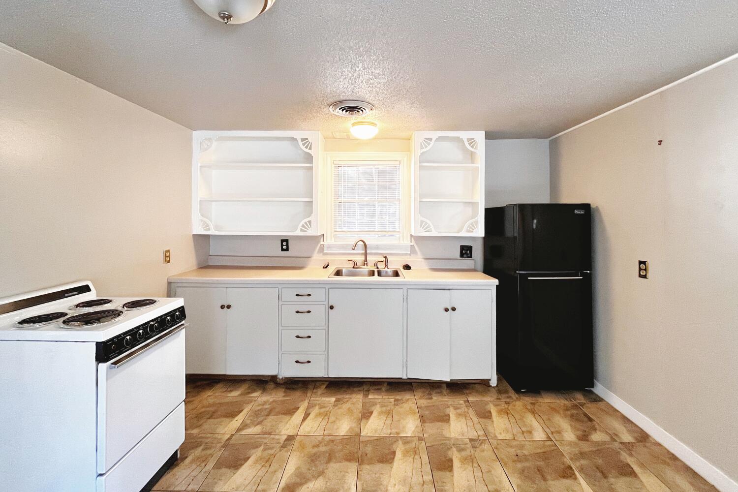 3002 21st Street Lubbock, TX 79410 - Photo 32 of 41 a kitchen with a sink and a refrigerator