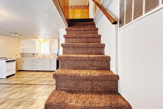 a view of a big room with wooden floor and windows