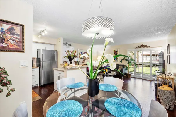 a dining room with furniture a kitchen and chandelier