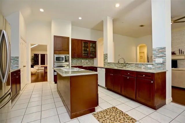 a large kitchen with stainless steel appliances kitchen island granite countertop a large counter top and stove