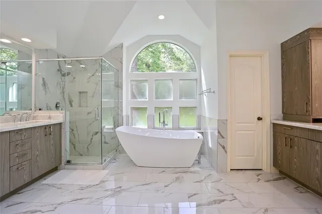 a spacious bathroom with a tub sink and mirror