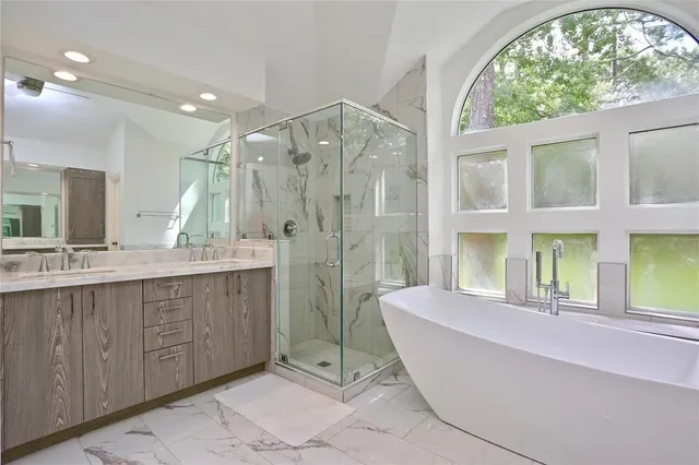 a spacious bathroom with a double vanity sink a mirror and a bathtub