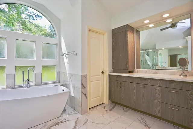 a bathroom with a tub sink and mirror