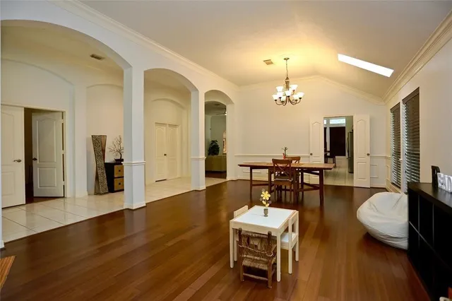 a living room with couches chairs and kitchen view with wooden floor
