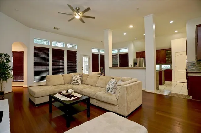 a living room with furniture and a large window with kitchen view