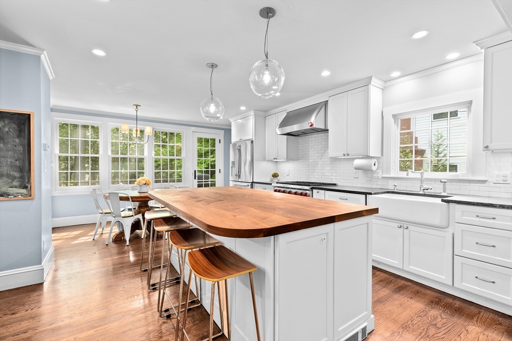 186 Nehoiden Road Newton, MA 02468 - Photo 3 of 21 a kitchen with stainless steel appliances granite countertop island wooden cabinets and a dining table