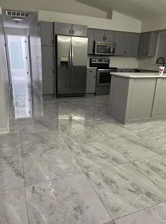 a kitchen with granite countertop a refrigerator and a stove top oven