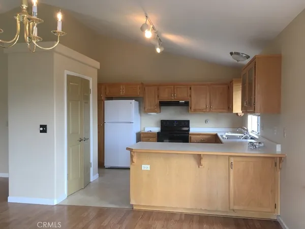 a kitchen with kitchen island granite countertop a sink a stove and refrigerator