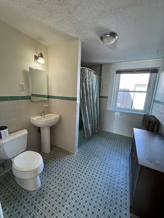 a bathroom with a toilet a sink and mirror