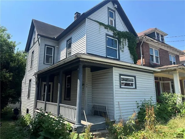 a view of a house with a window and potted plants