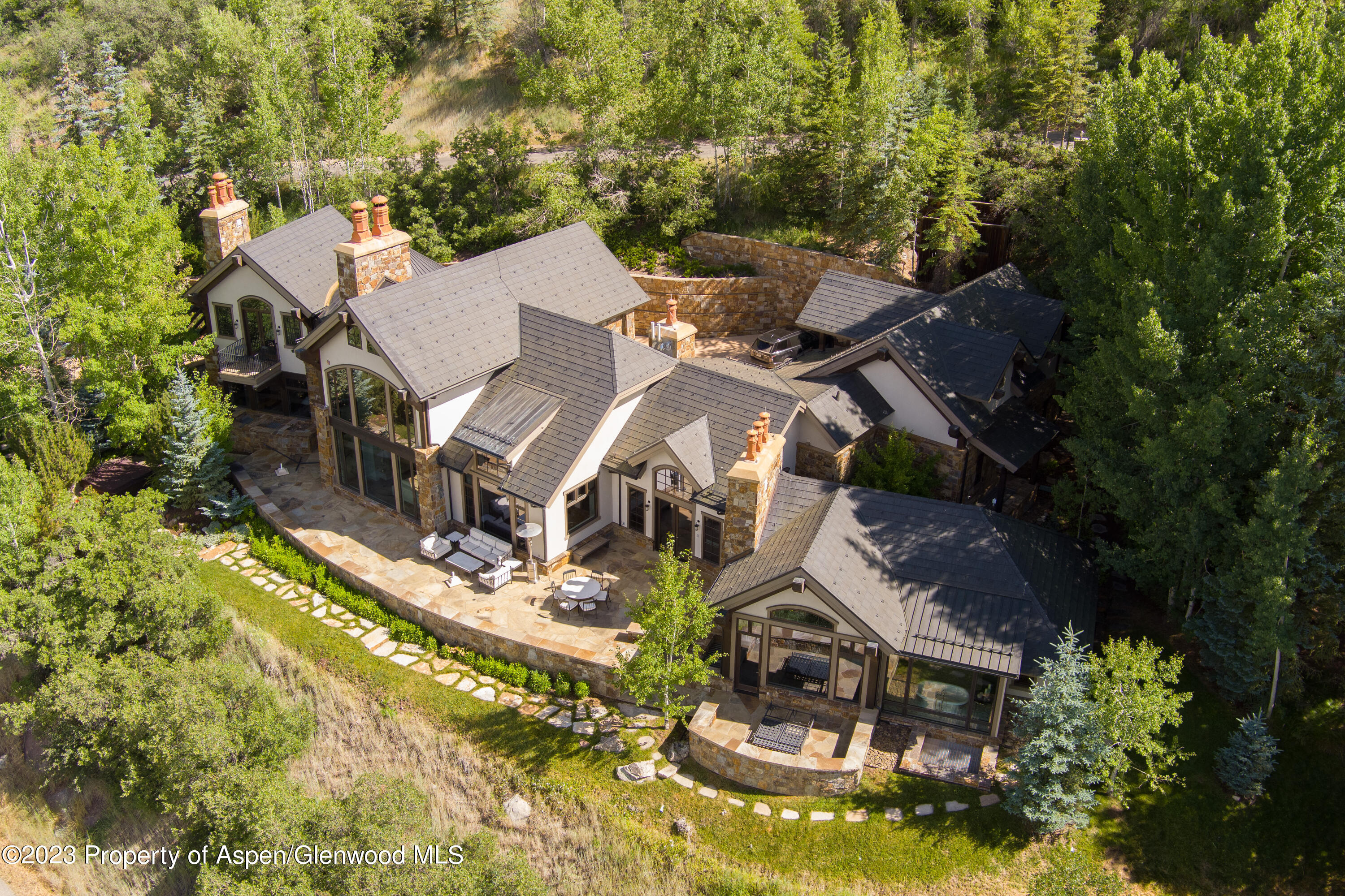 an aerial view of a house with a garden and trees