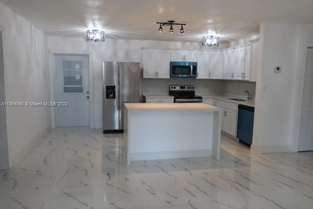 a kitchen with stainless steel appliances granite countertop a stove top oven a refrigerator a sink and dishwasher