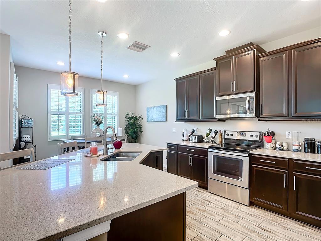 4744 Wandering Way Wesley Chapel, FL 33544 - Photo 14 of 39 a kitchen with stainless steel appliances granite countertop a sink counter space cabinets and furniture