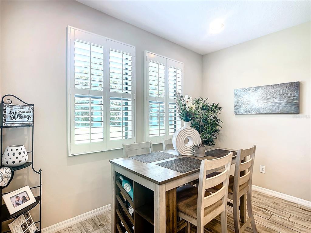 4744 Wandering Way Wesley Chapel, FL 33544 - Photo 15 of 39 a view of a dining room with furniture and wooden floor