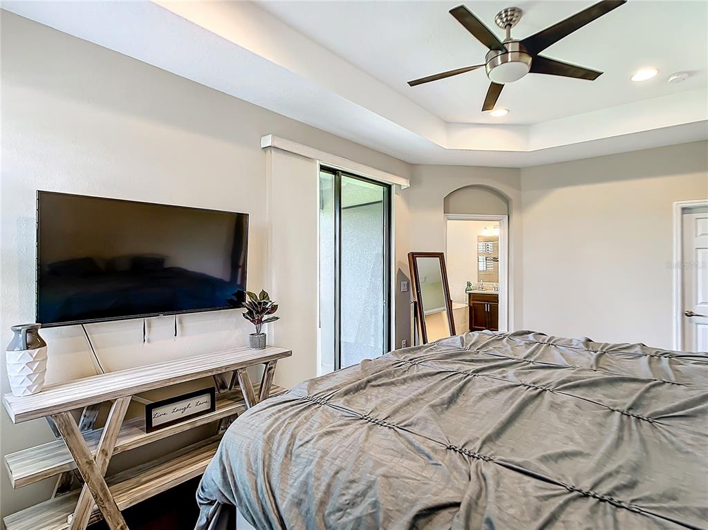 4744 Wandering Way Wesley Chapel, FL 33544 - Photo 17 of 39 a bedroom with a bed and a flat screen tv