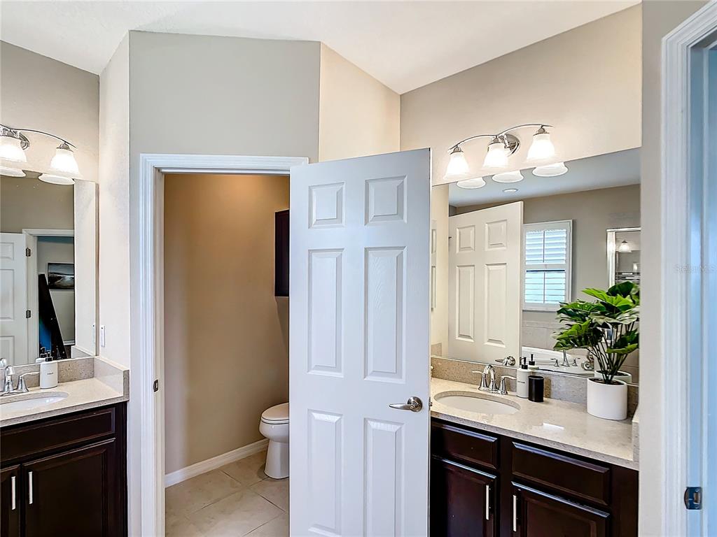 4744 Wandering Way Wesley Chapel, FL 33544 - Photo 22 of 39 a bathroom with a sink and a mirror